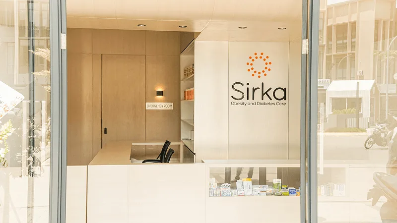 Resepsionis Sirka Clinic dengan logo dan meja konsultasi
